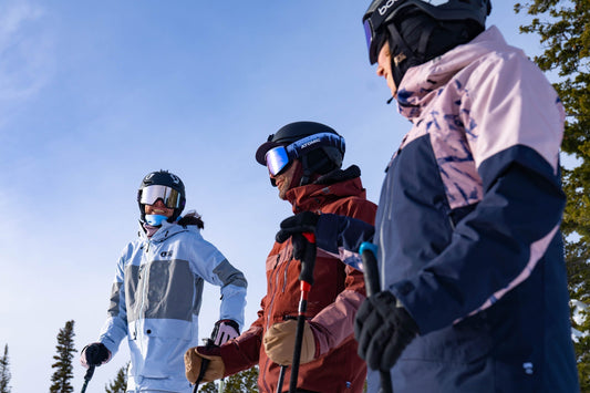 Three colleagues chat and enjoy the fresh mountain air while on their corporate ski trip