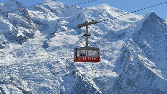 The Brevent telepherique is suspended on cables with a glaciated Chamonix mountainscape behind it. 
