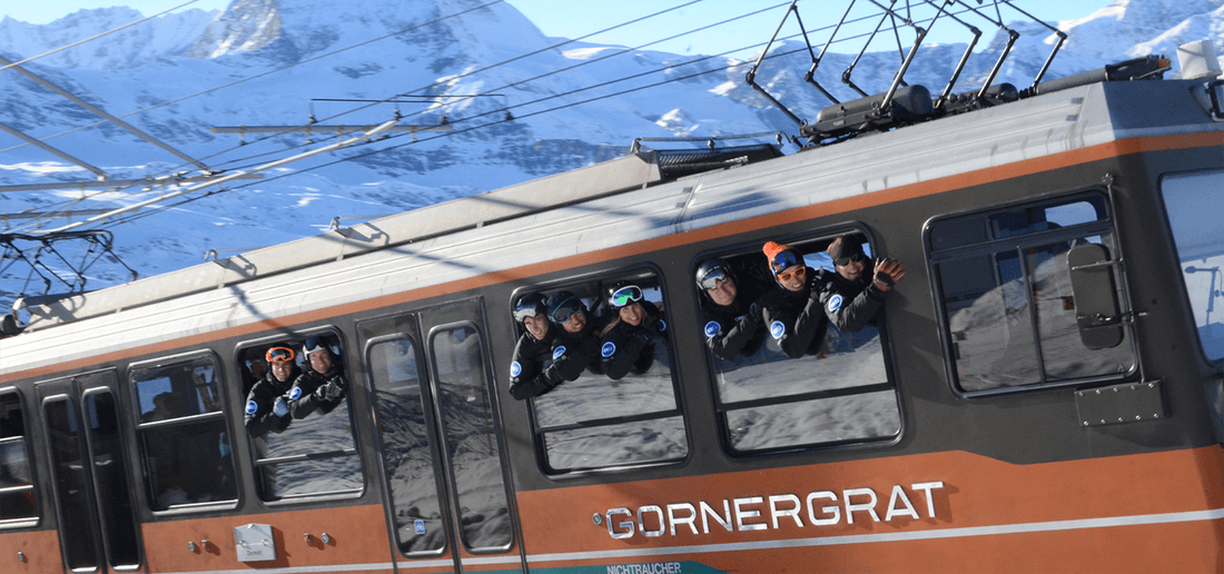 European snowsport ski instructors hanging out the window of the Gornergrat train in Zermatt. 