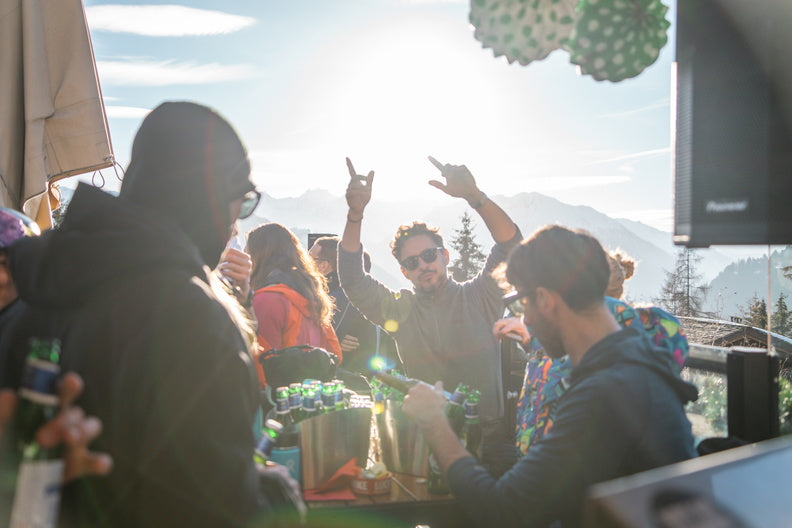 A man enjoys drinks with his friends on an outdoor terrace at the Farinet in Verbier. 