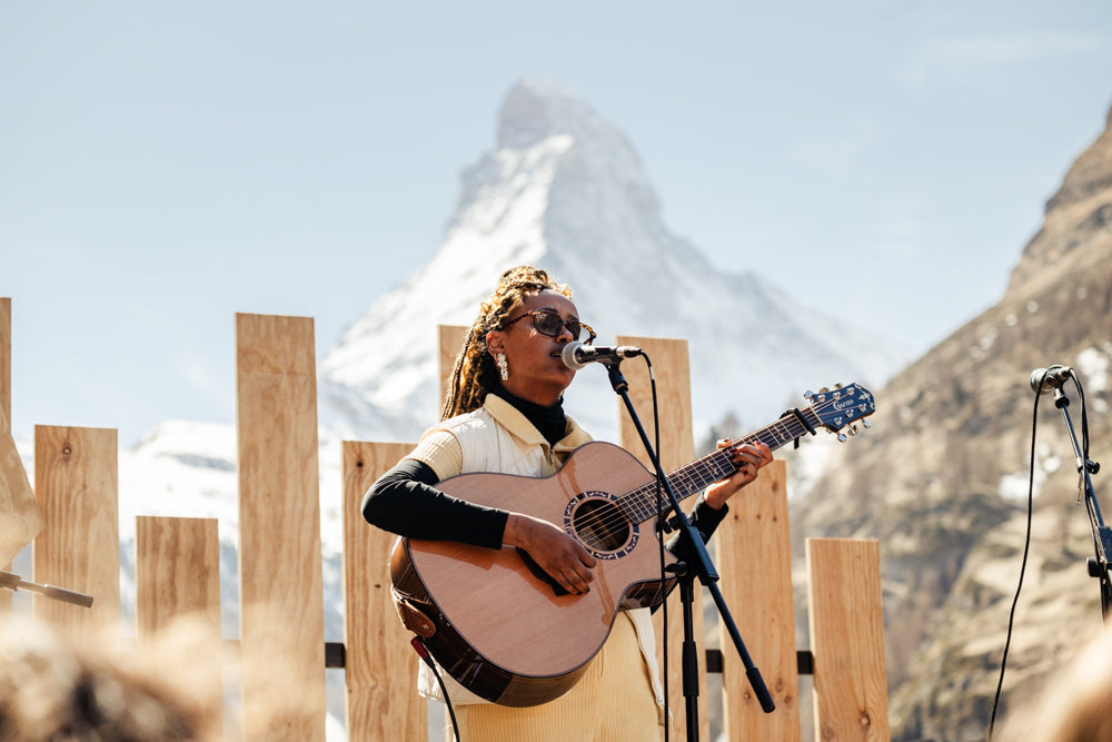 Noemi Beza plays guitar and sings to a crowd in front of the Matterhorn at Zermatt Unplugged