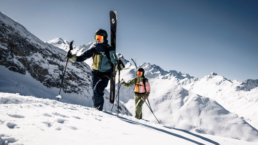 Skiers in secondhand Ortovox outfits hike through a beautiful winter mountainscape. 